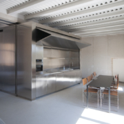 Arredo appartamento Palazzo Rhinoceros con blocco in inox che contiene la cucina e bascula motorizzata