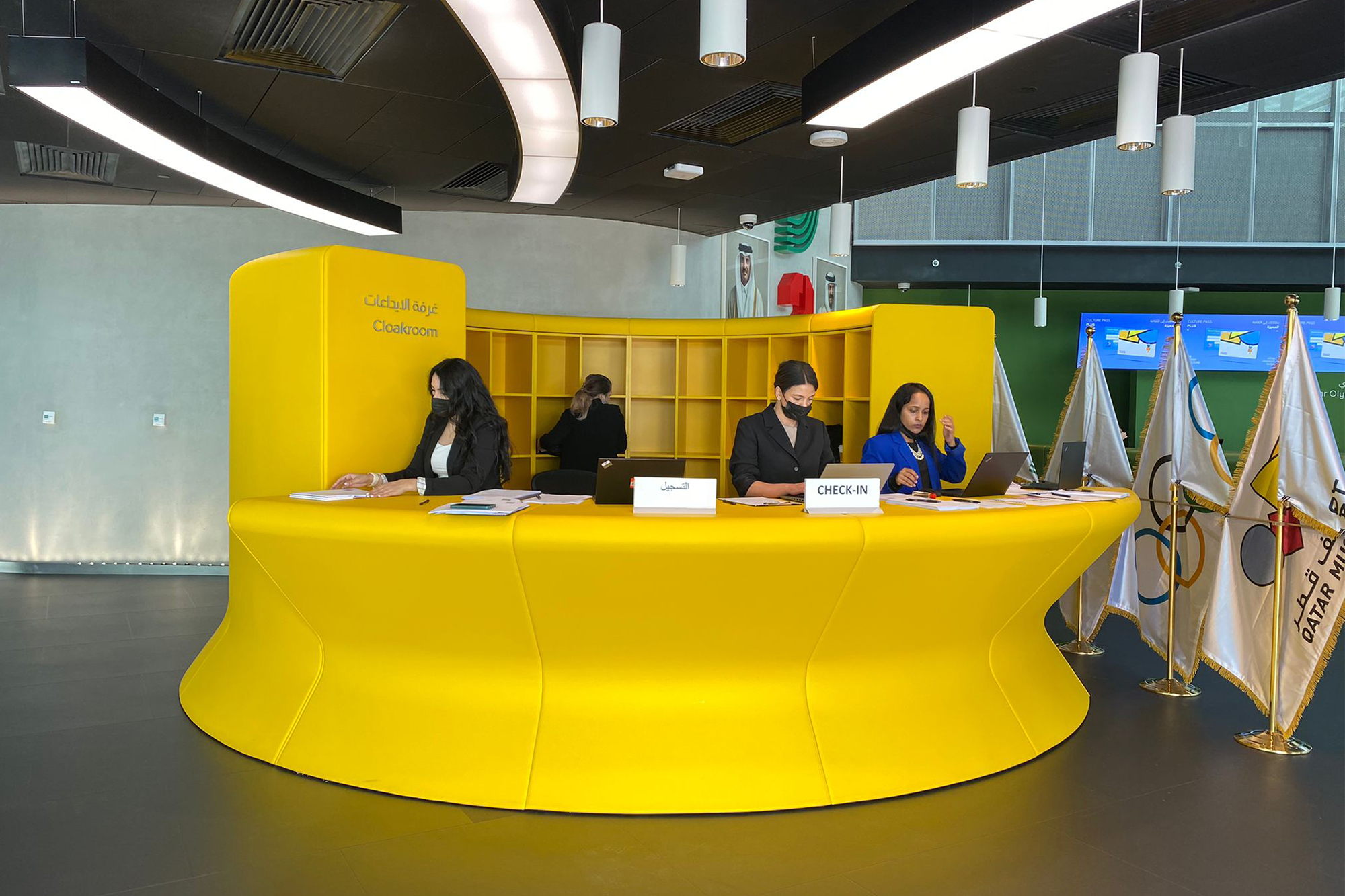 curving yellow reception desk, receptionists
