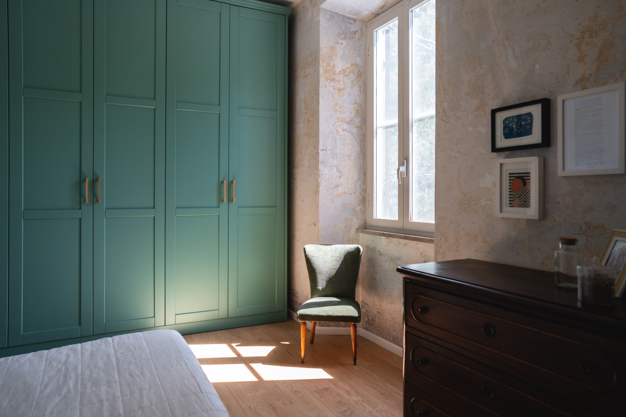 bedroom with wardrobe, window and armchair